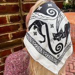 A woman wearing the Screenprinted Chat Noir Cotton Bandana around her head.