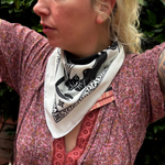 A woman wearing the Screenprinted Chat Noir Cotton Bandana around her neck.