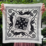 Someone holding the Screenprinted Chat Noir Cotton Bandana up to show off its design.