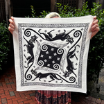 Someone holding the Screenprinted Chat Noir Cotton Bandana up to show off its design.
