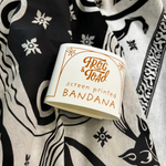 An up close image of the packaging on the Screenprinted Chat Noir Cotton Bandana.