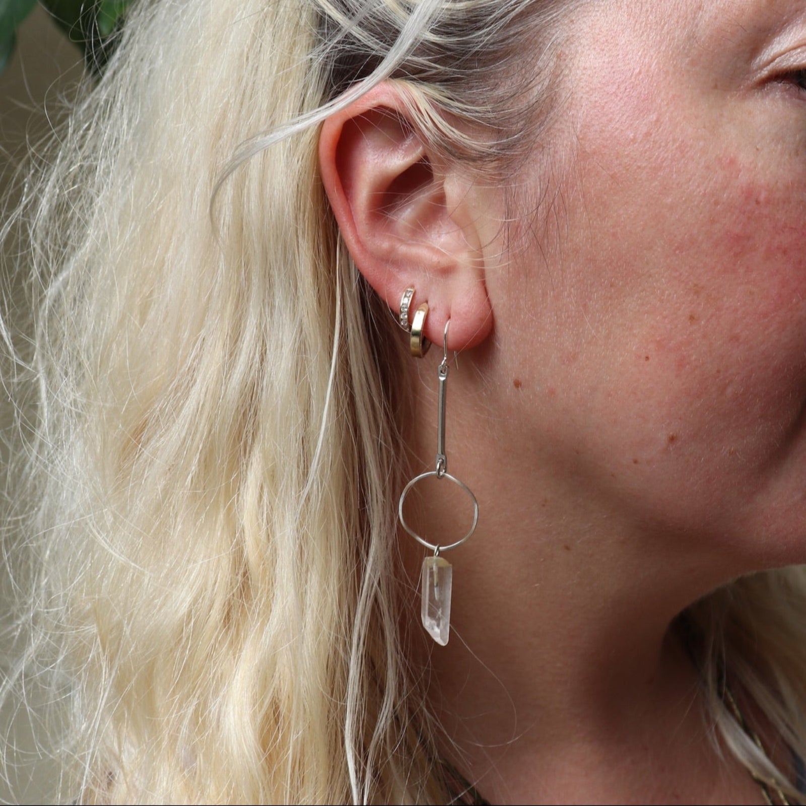 Someone wearing the silver Quartz Crystal Drop Earrings.