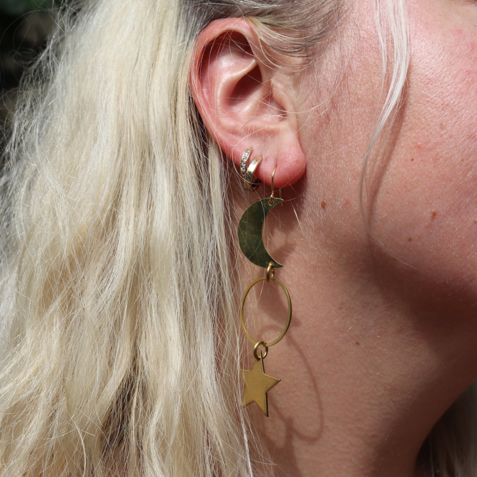 Someone wearing the Brass Rhiannon Moon and Star 3 inch. Earrings.