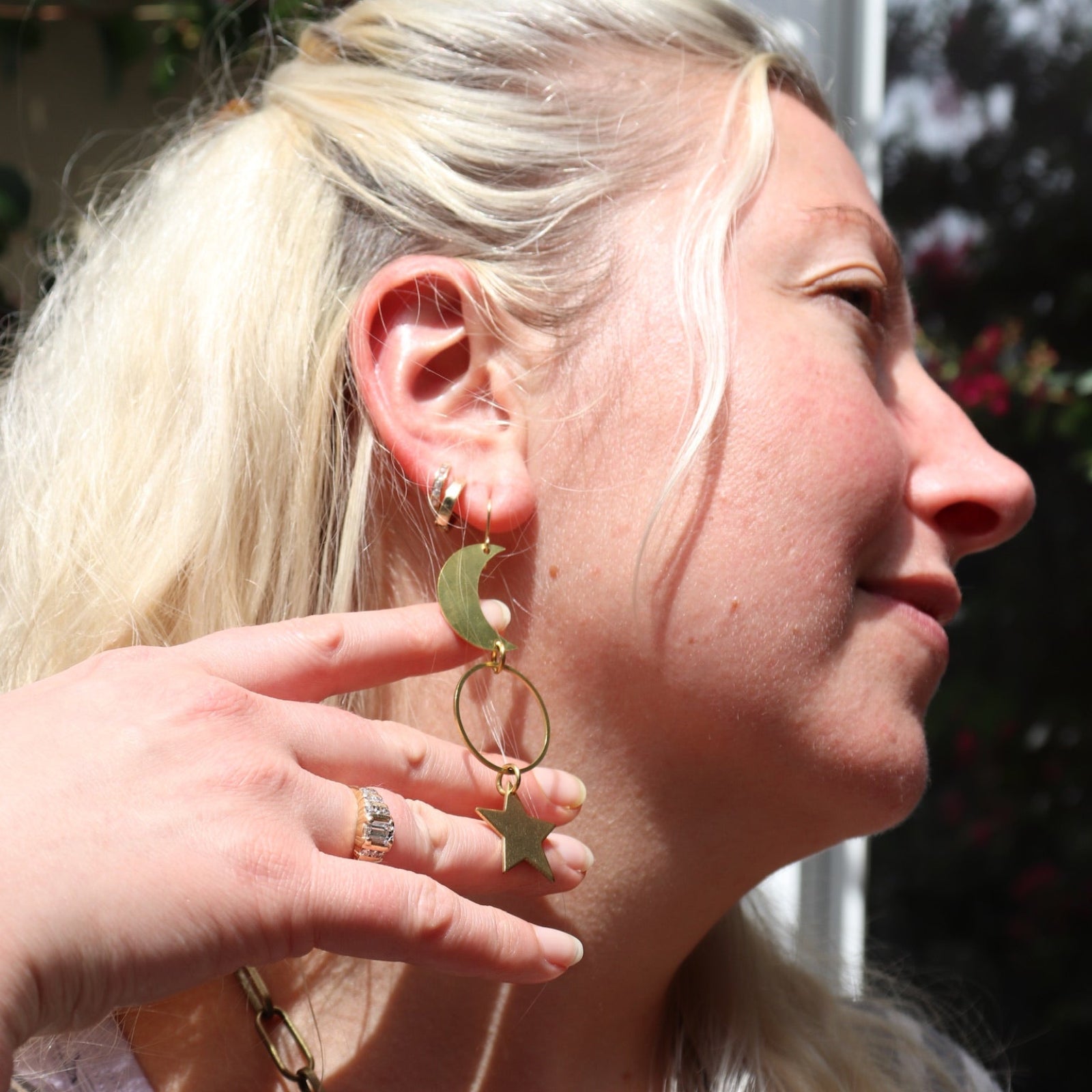 Someone wearing the Brass Rhiannon Moon and Star 3 inch. Earrings.