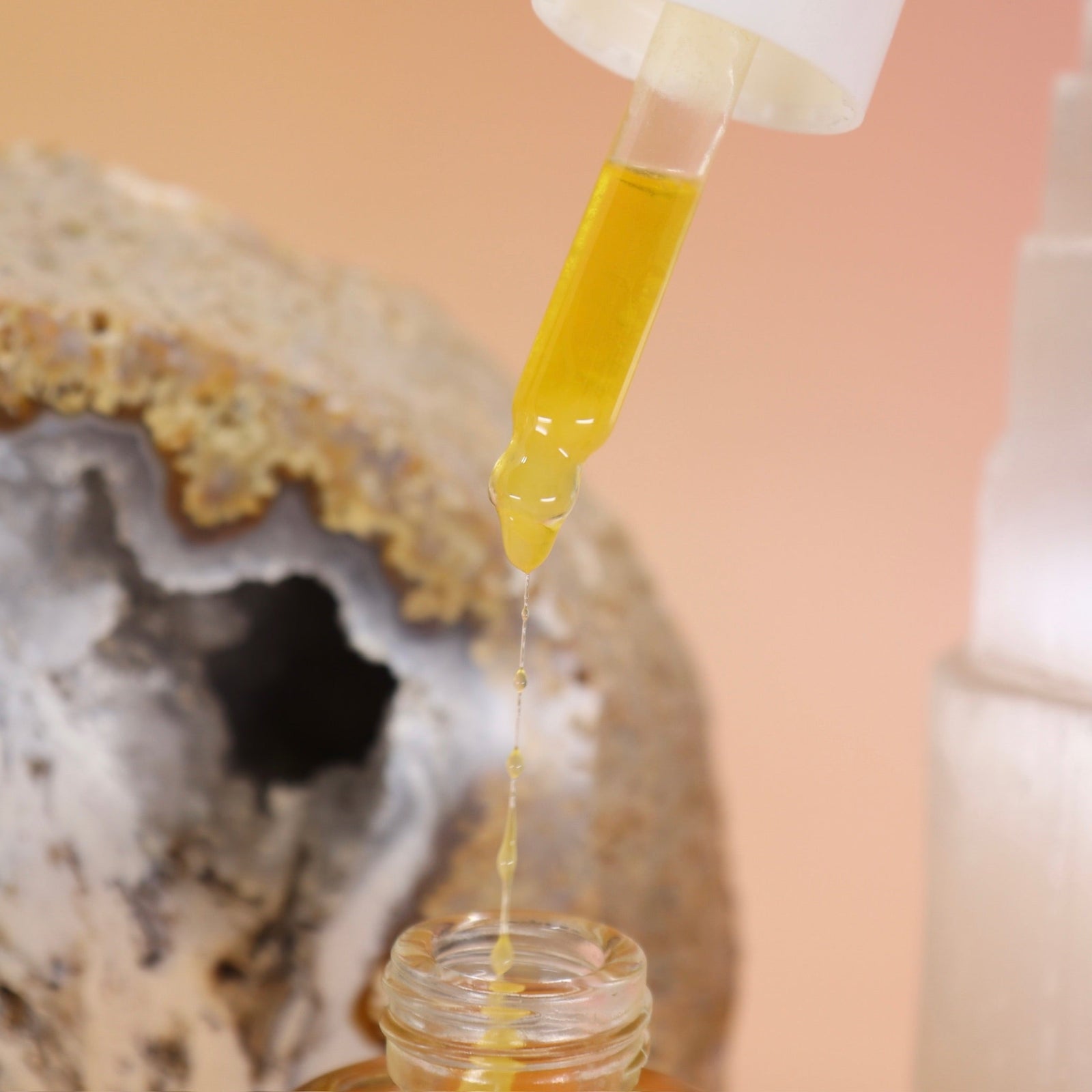 An up-close image of Anti-Aging Elixir Face Oil from Bohemian Rêves dropper with the serum coming out.