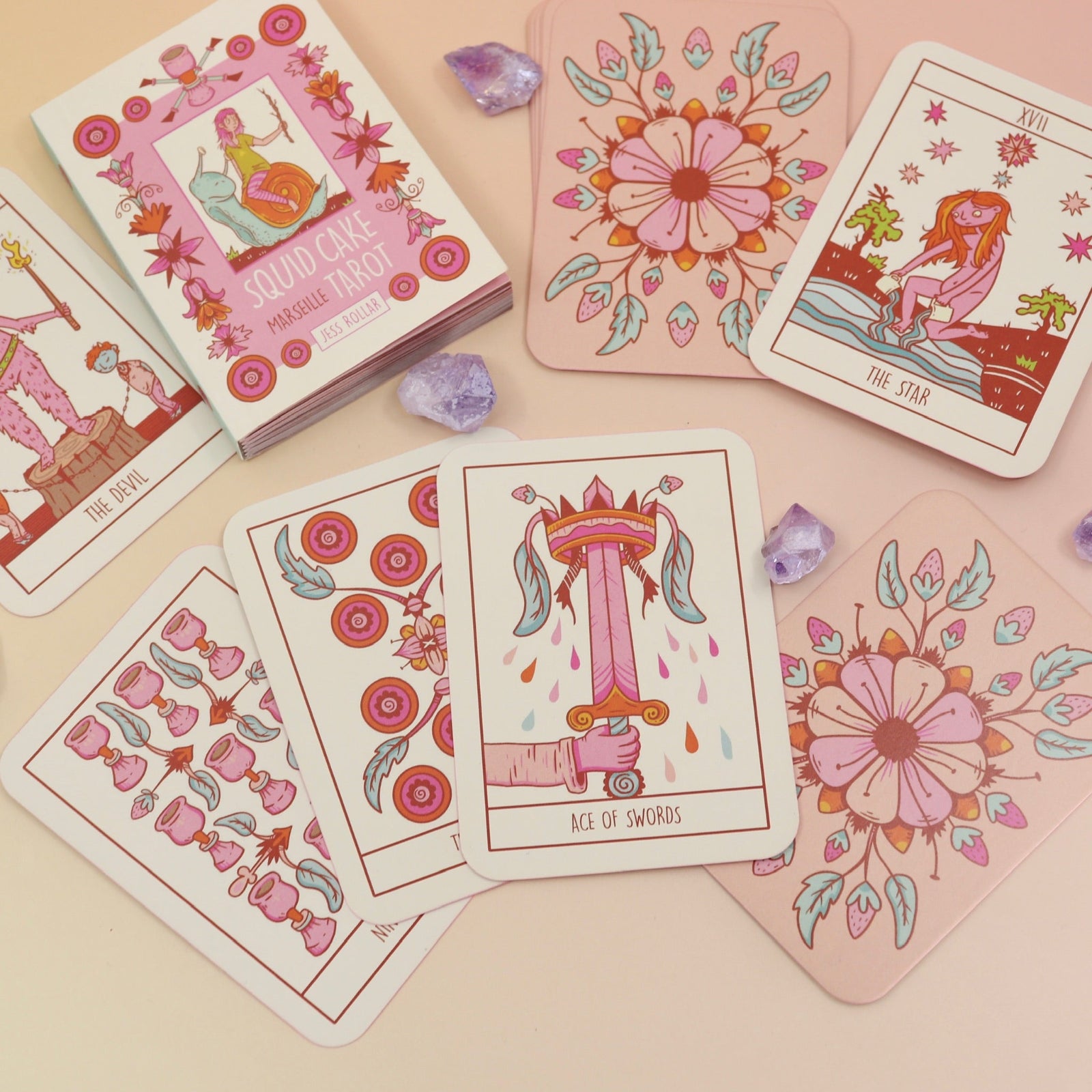 The contents of the Squid Cake Marseille Tarot Deck all on a pink and yellow background.