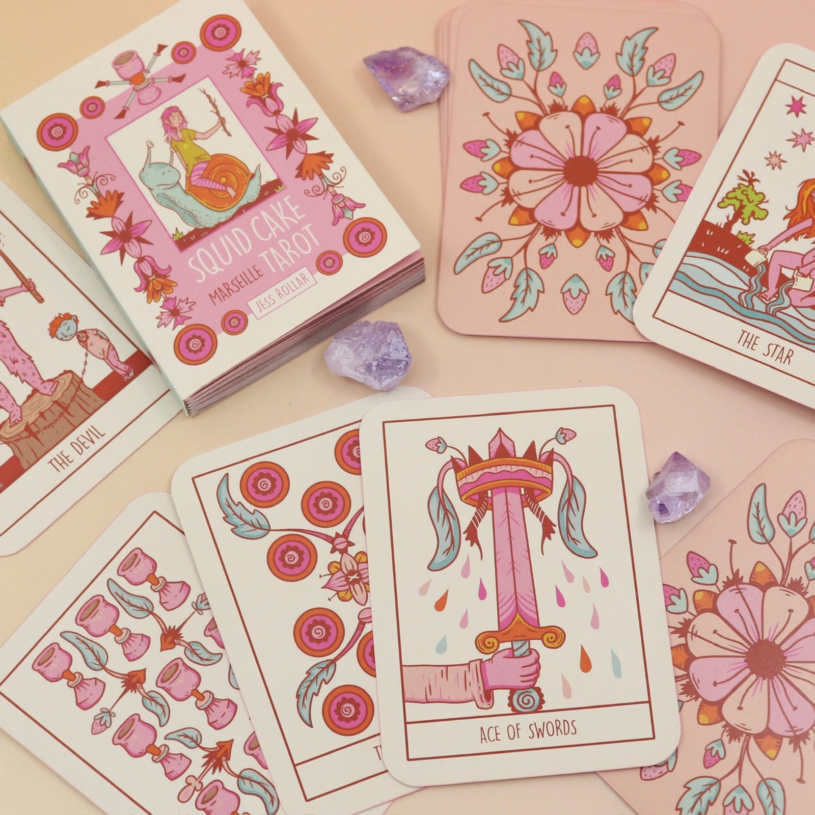 The contents of the Squid Cake Marseille Tarot Deck all on a pink and yellow background.