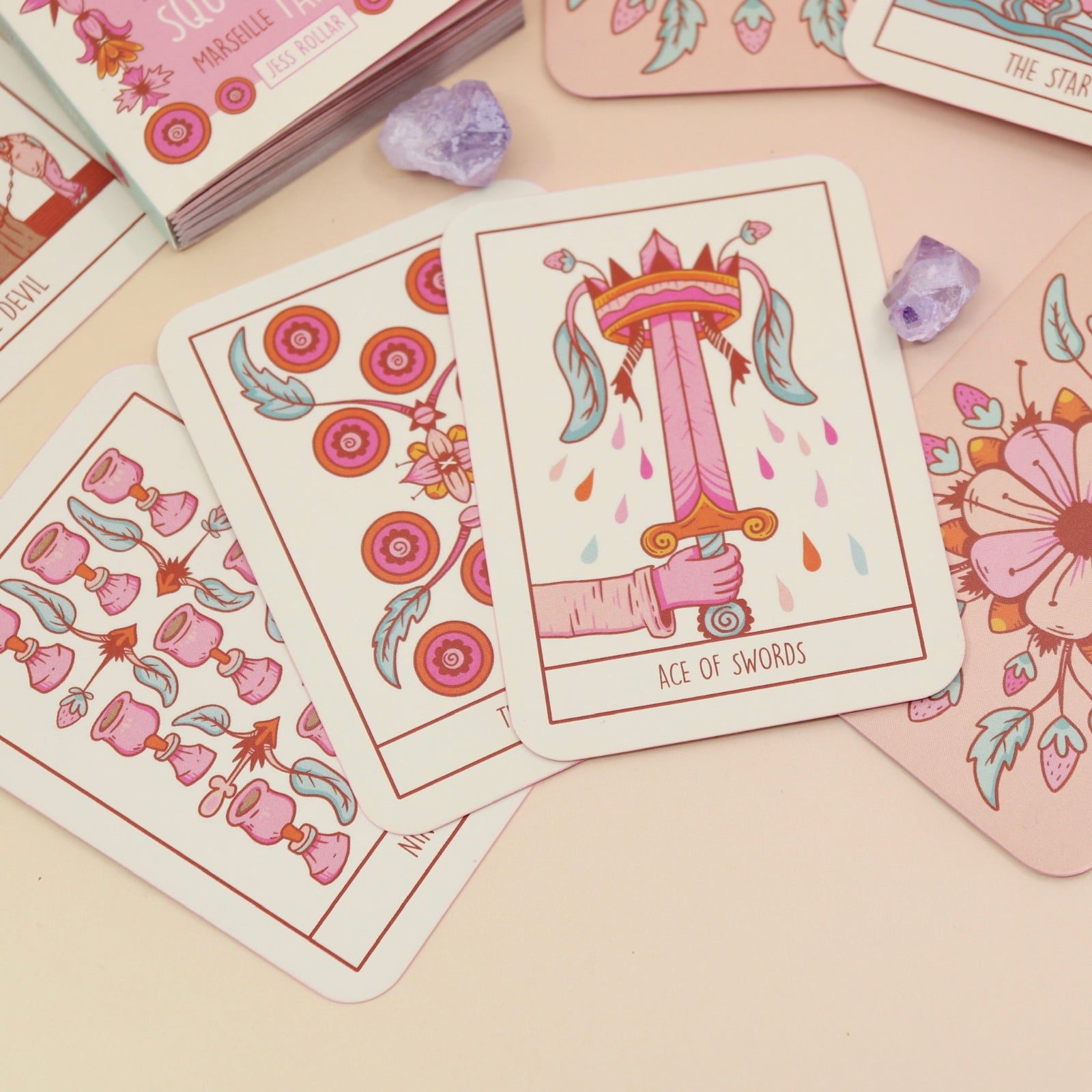 The contents of the Squid Cake Marseille Tarot Deck all on a pink and yellow background.