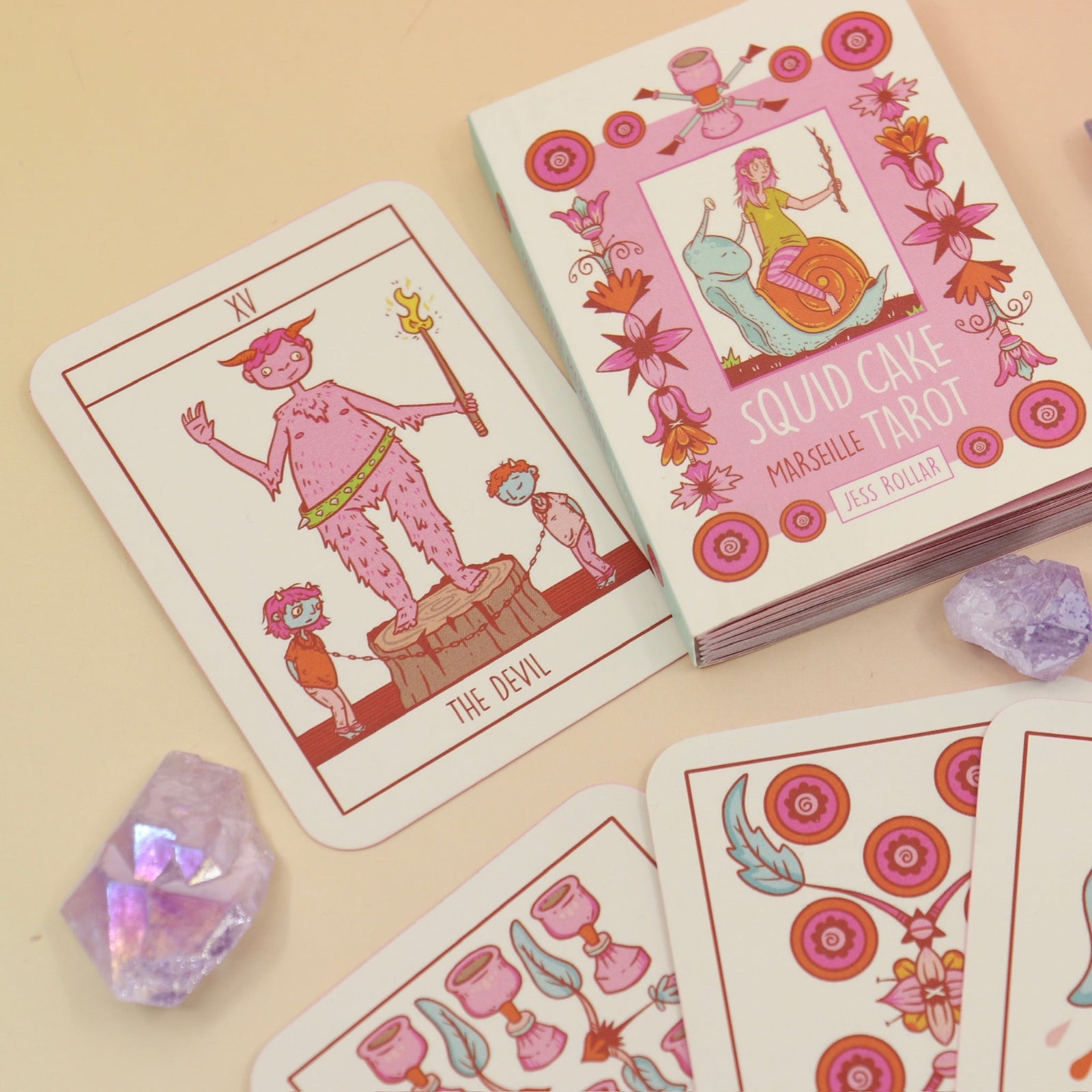 The contents of the Squid Cake Marseille Tarot Deck all on a pink and yellow background.