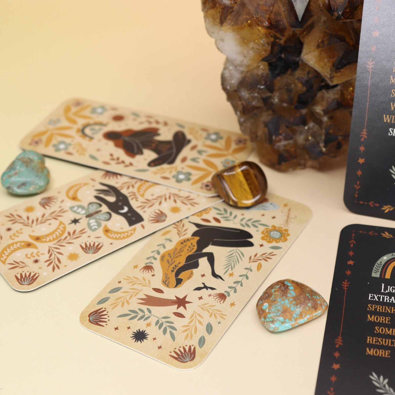 The Witch Magick Affirmation + Divination Cards against a citrine piece and all over on a pink and yellow background.