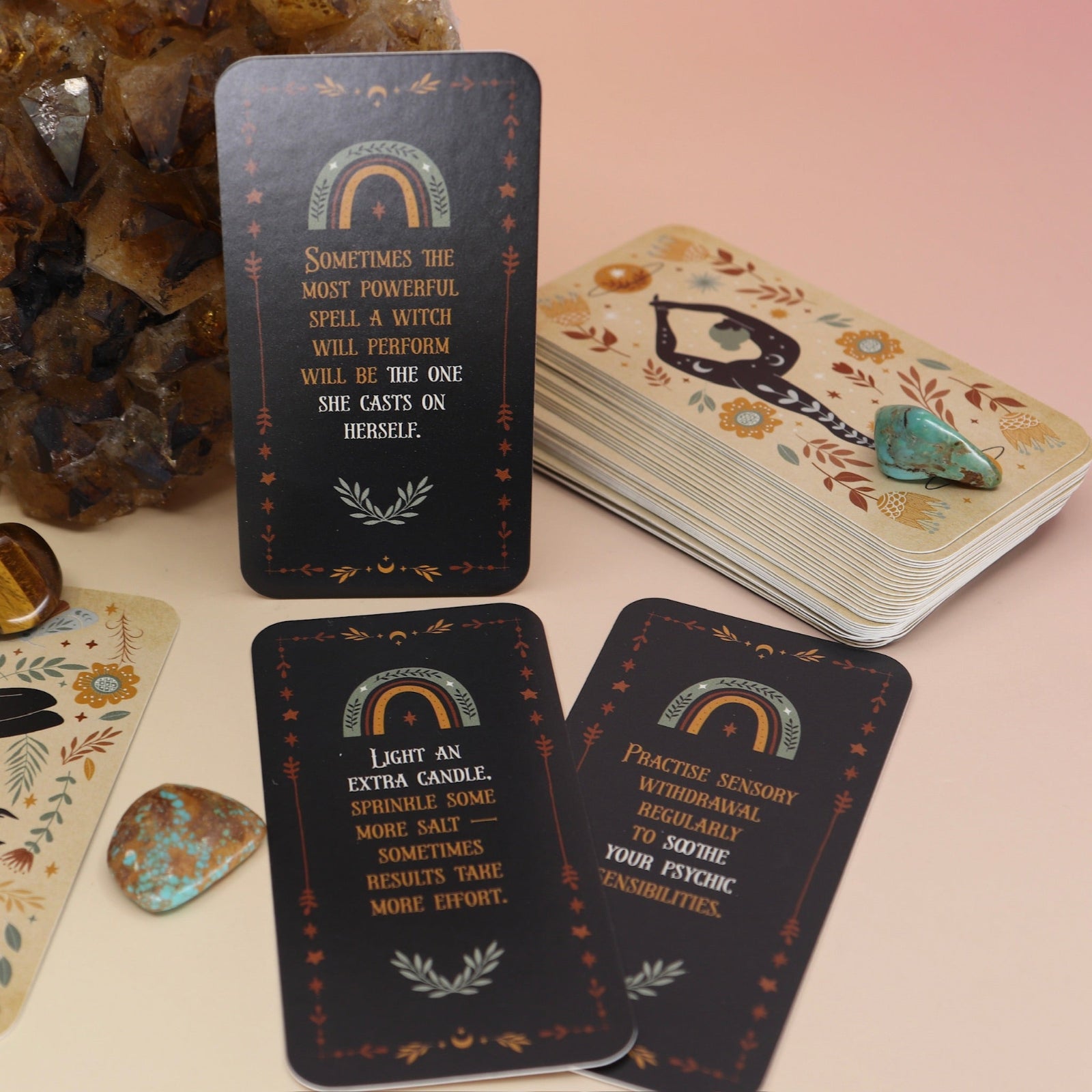 The Witch Magick Affirmation + Divination Cards against a citrine piece and all over on a pink and yellow background.