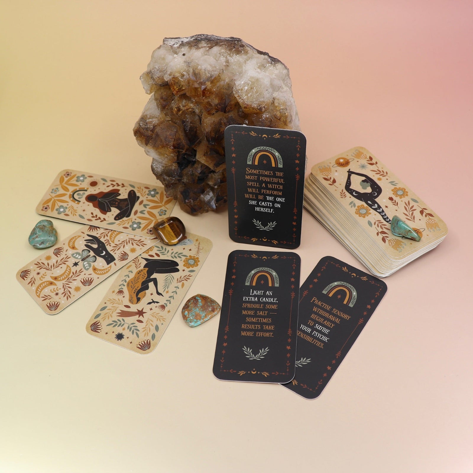 The Witch Magick Affirmation + Divination Cards against a citrine piece and all over on a pink and yellow background.