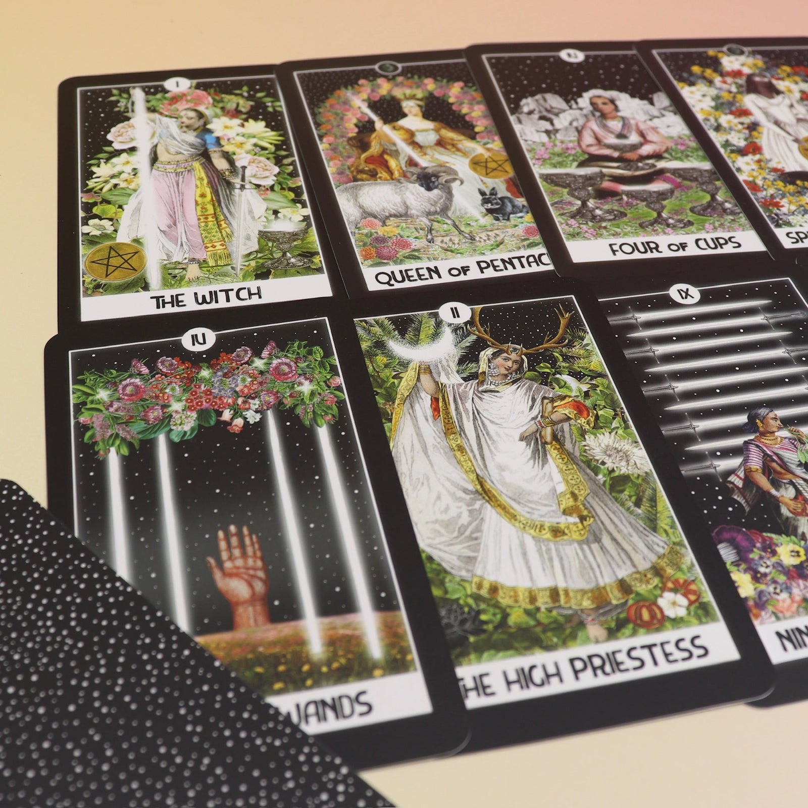The contents of the Intuitive Night Goddess Tarot Deck on a pink and yellow background.