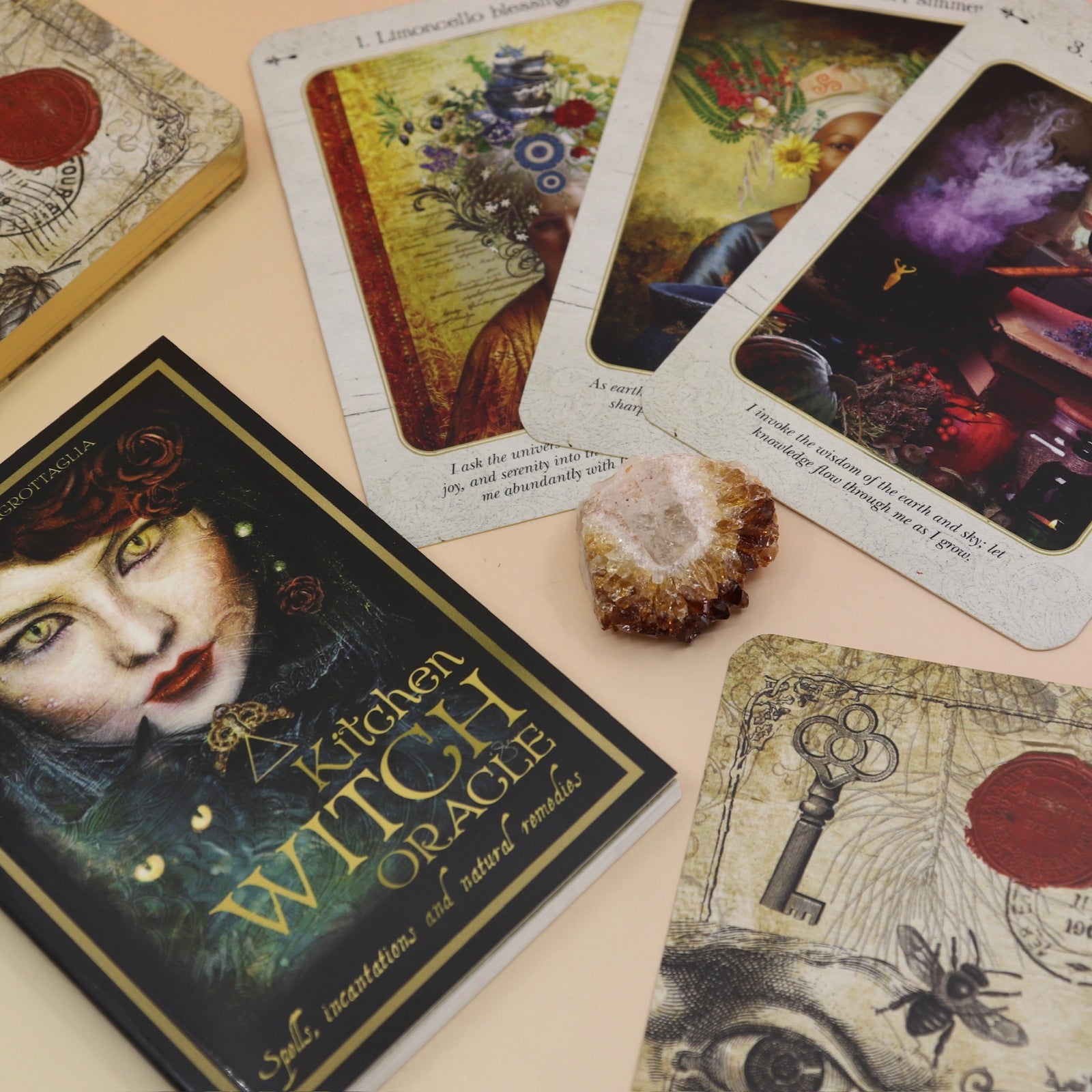 The contents of the Kitchen Witch Oracle Deck on a pink and yellow background.