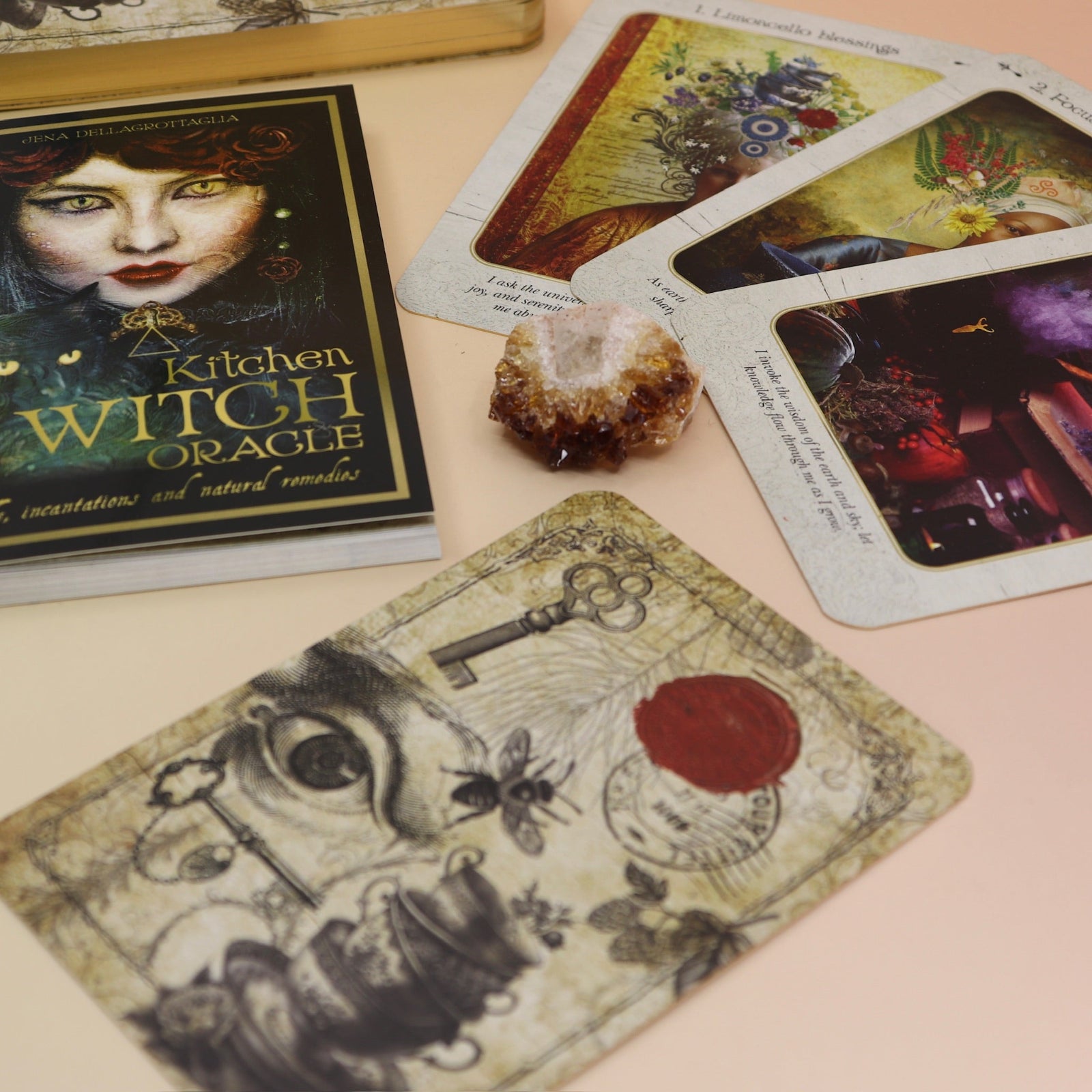 The contents of the Kitchen Witch Oracle Deck on a pink and yellow background.