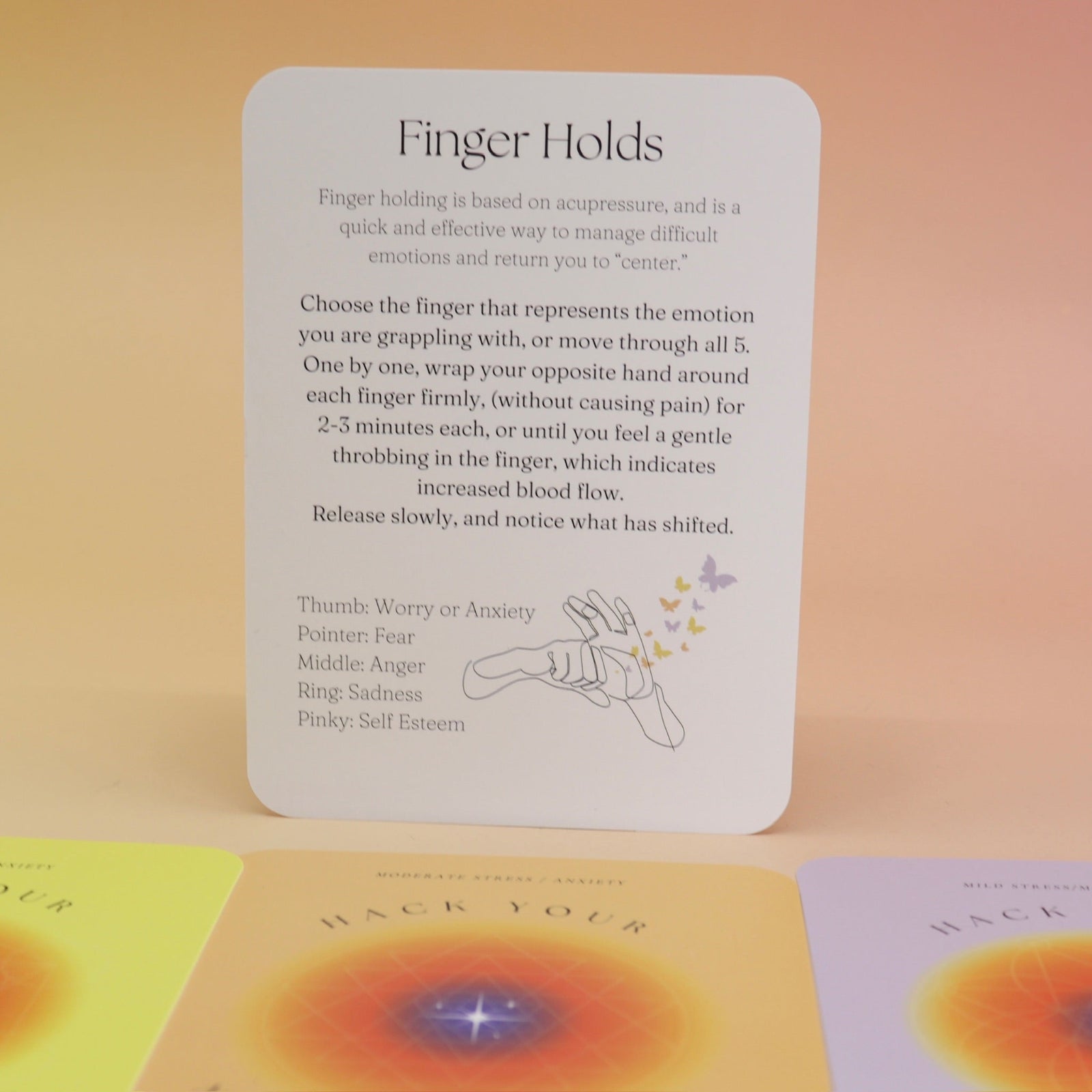 The contents of the Hack Your Nervous System card deck on a pink and yellow background.
