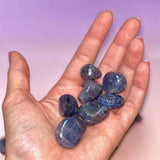 Hand holding blue stones against a blurred background