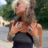 Woman wearing multiple pieces of Larimar jewelry outdoors