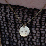 Someone wearing the Libra 14k Gold Dipped Nickel-Free Zodiac Necklace with a black net top.