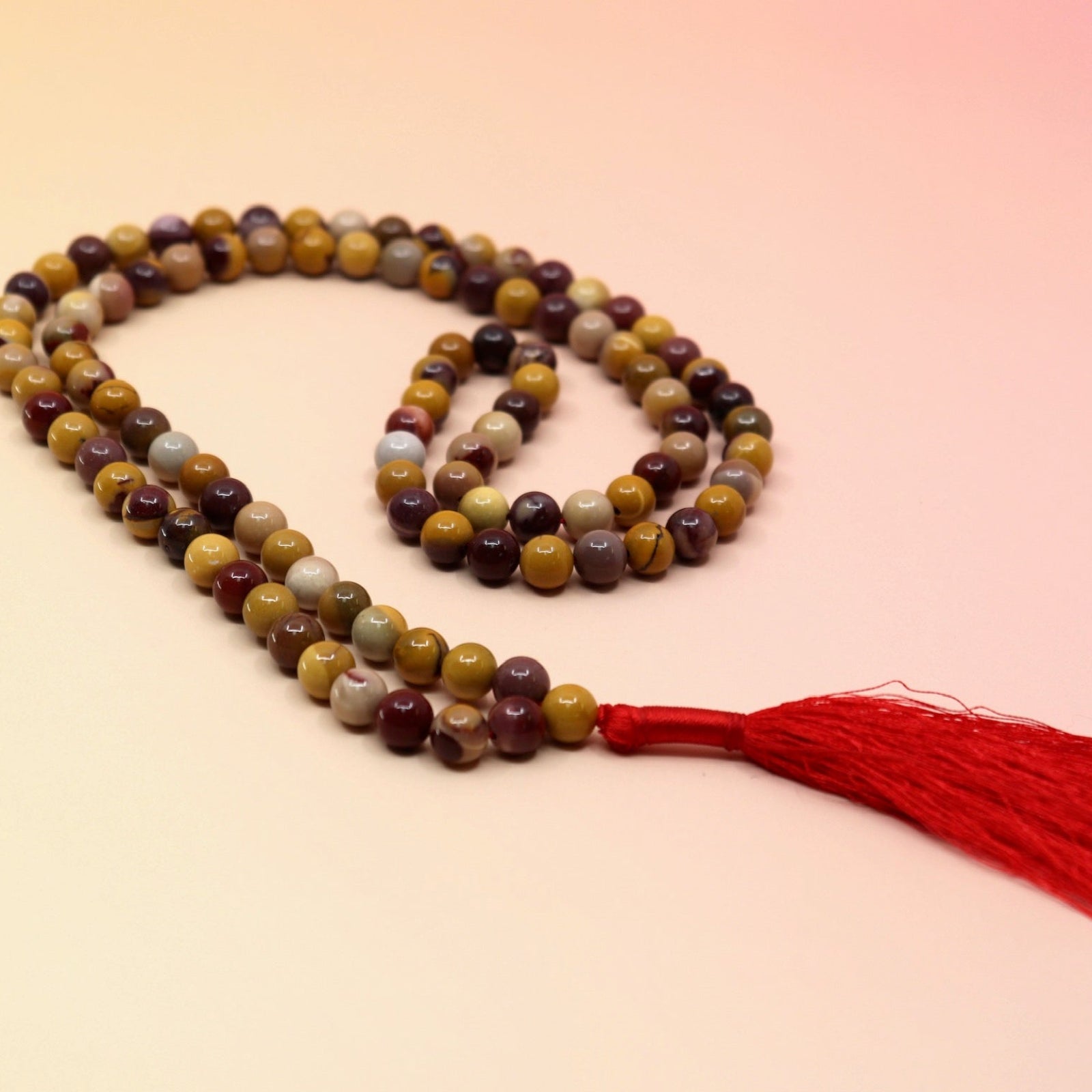 Mookaite Jasper 108 Mala Necklace on pink and orange background