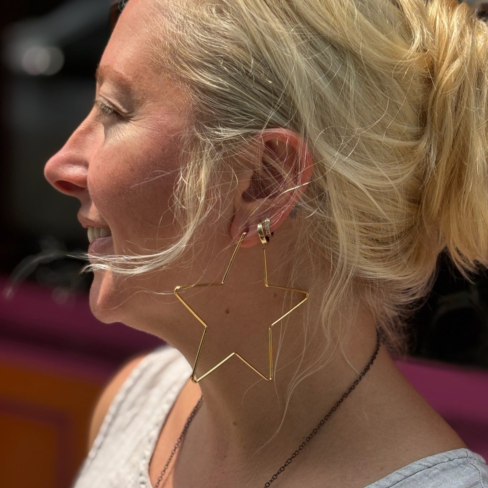 Boho style model smiling with large star earrings