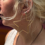Close-up of 18K gold star hoop earring on ear