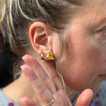 hand holding back of hear to showcase the own it stud