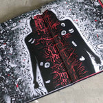 Book with a black and red illustration of a creature on a textured surface