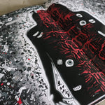 Skateboard deck with black and red design on a textured surface