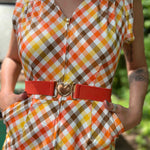 girl in 1970s Gingham Belted Romper in front of green VW vintage bus