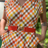 girl in 1970s Gingham Belted Romper in front of green VW vintage bus