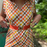 girl in 1970s Gingham Belted Romper in front of green VW vintage bus