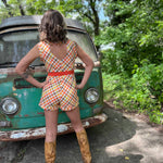 girl in 1970s Gingham Belted Romper in front of green VW vintage bus