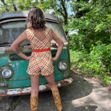 girl in 1970s Gingham Belted Romper in front of green VW vintage bus