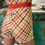 girl in 1970s Gingham Belted Romper in front of green VW vintage bus