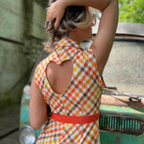 girl in 1970s Gingham Belted Romper in front of green VW vintage bus