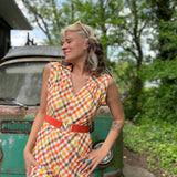 girl in 1970s Gingham Belted Romper in front of green VW vintage bus