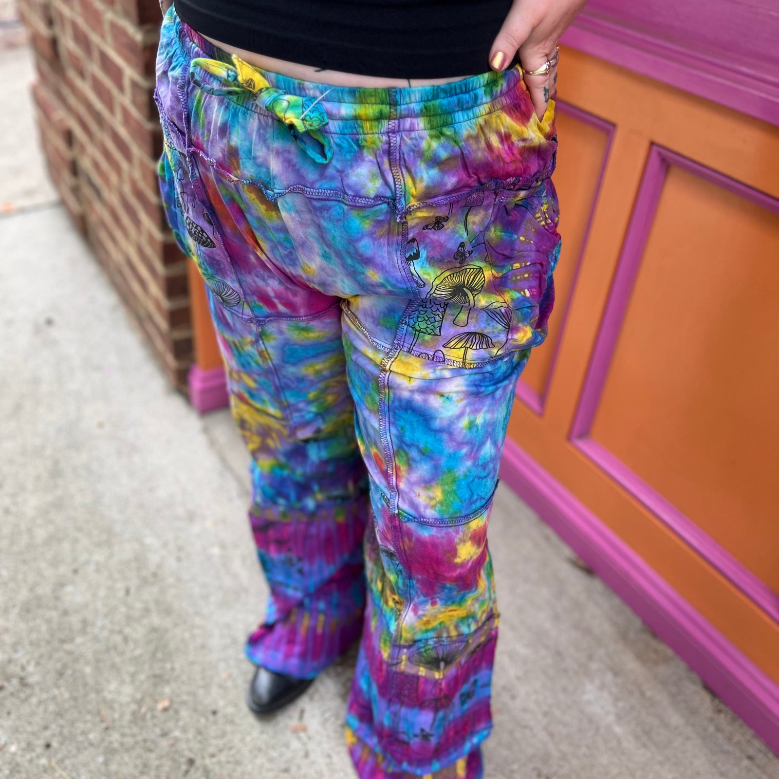 A woman wearing the Rainbow Tie Dye Pocket Bell Cotton Trouser.