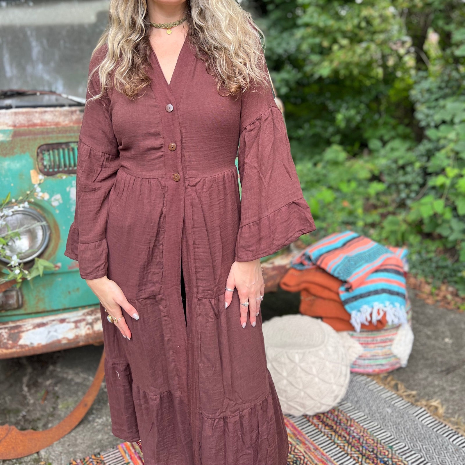 A woman wearing the marron brown Organic Tiered Maxi Kimono Wrap Dress in front of a vintage Volkswagen bus.