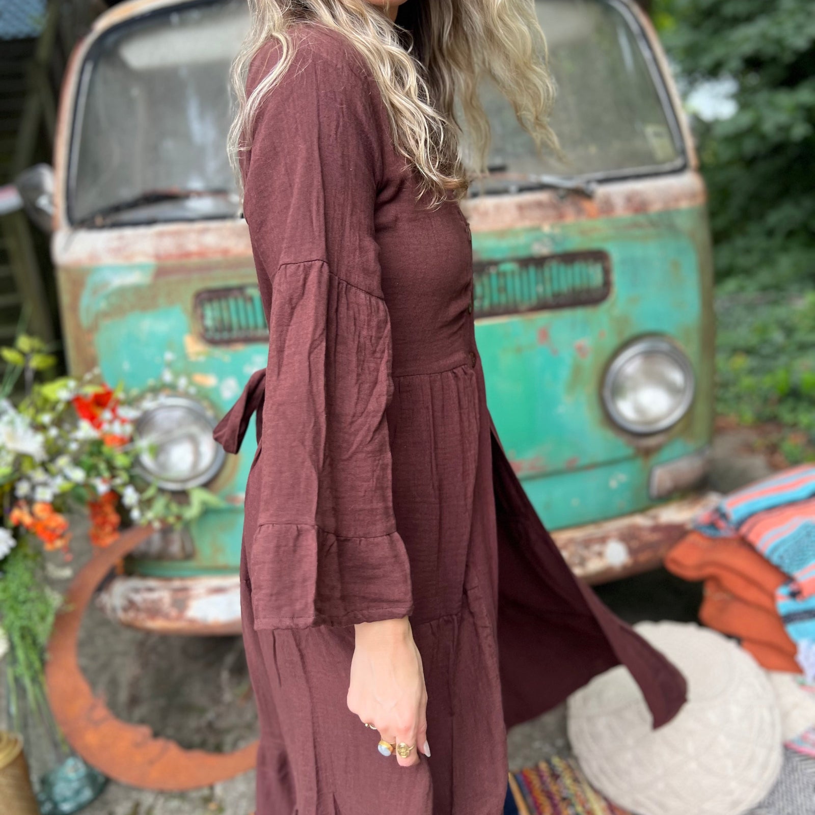 A woman wearing the marron brown Organic Tiered Maxi Kimono Wrap Dress in front of a vintage Volkswagen bus.