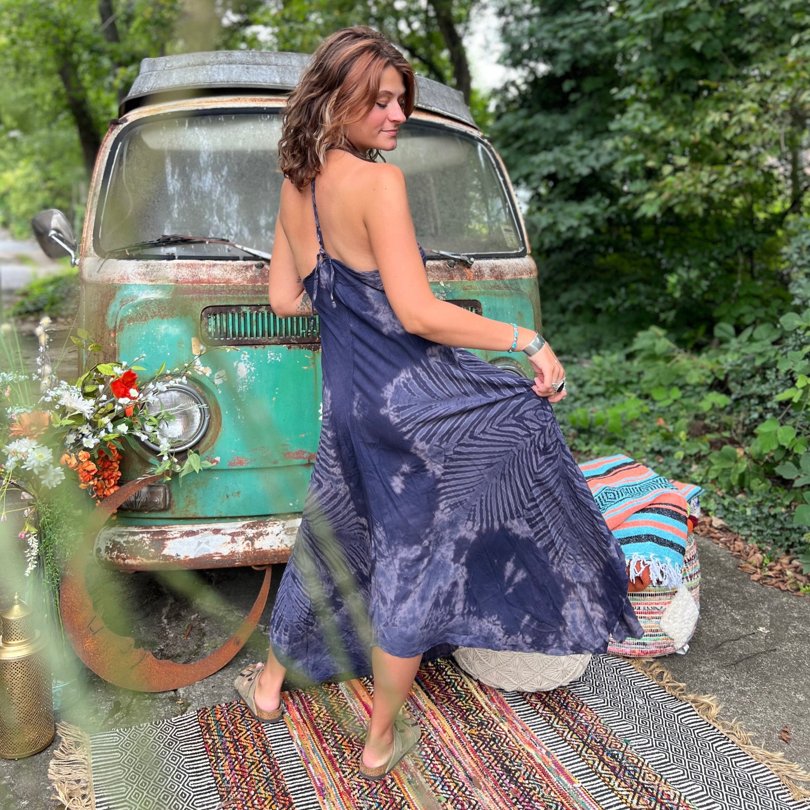 A woman wearing the spellbound Hippie Boho Maxi Flowy Tie Dye Dress in front of a vintage Volkswagen Bus.