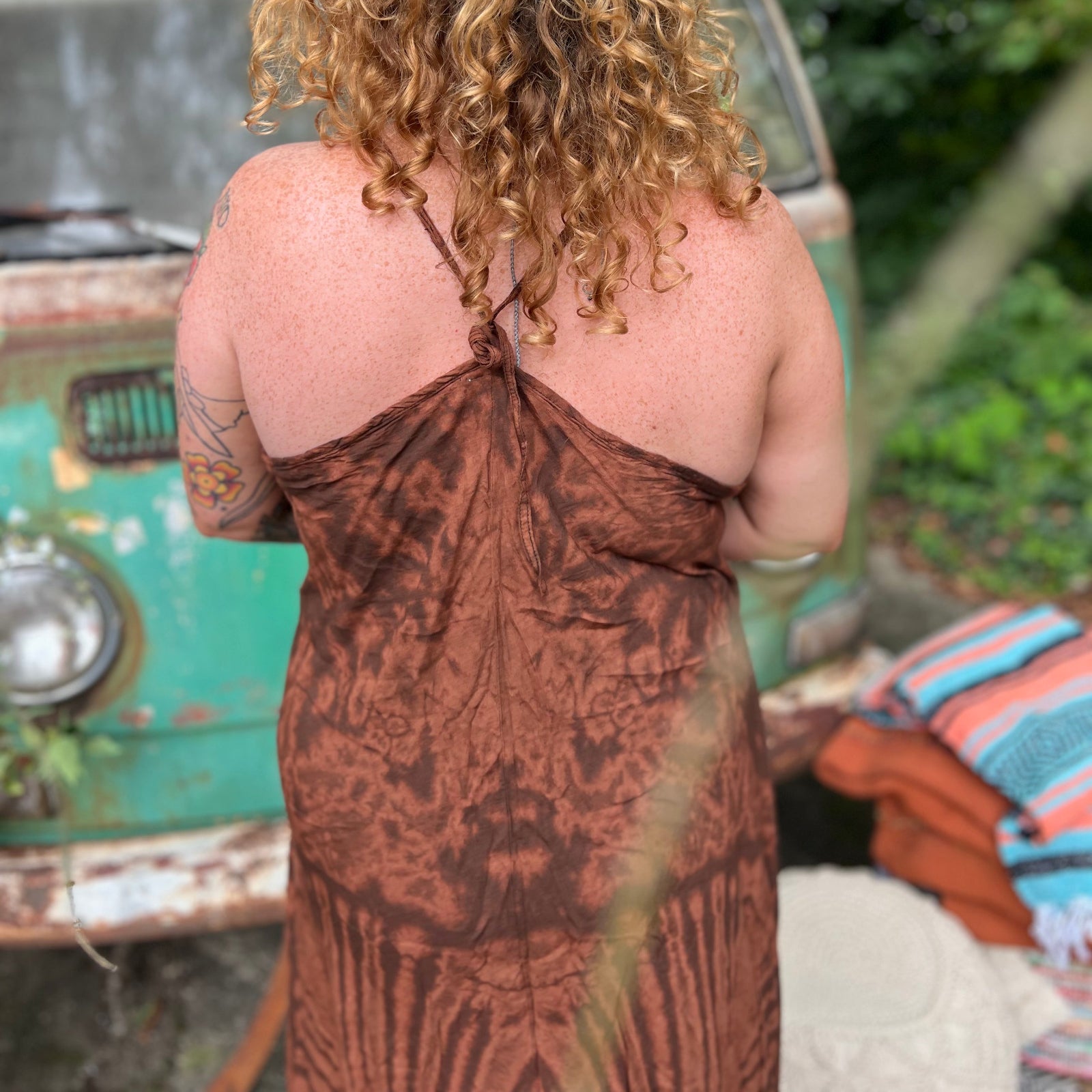 A woman wearing the amber gold Hippie Boho Maxi Flowy Tie Dye Dress in front of a vintage Volkswagen Bus.