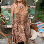 A woman wearing the moondance mauve gold Hippie Boho Maxi Flowy Tie Dye Dress in front of a vintage Volkswagen Bus.