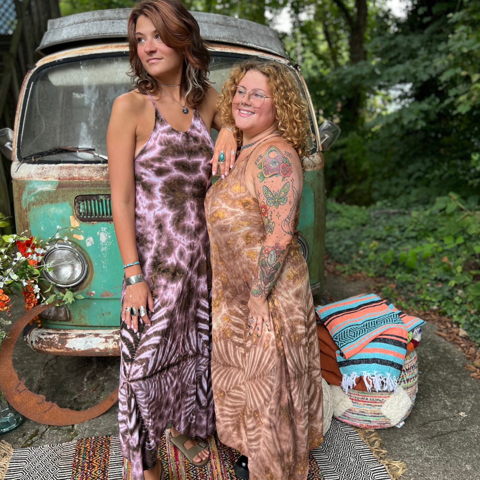 Two women wearing the moondance mauve gold Hippie Boho Maxi Flowy Tie Dye Dress in front of a vintage Volkswagen Bus.