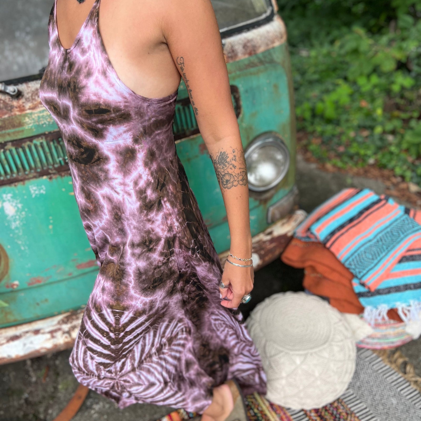 A woman wearing the moondance mauve gold Hippie Boho Maxi Flowy Tie Dye Dress in front of a vintage Volkswagen Bus.