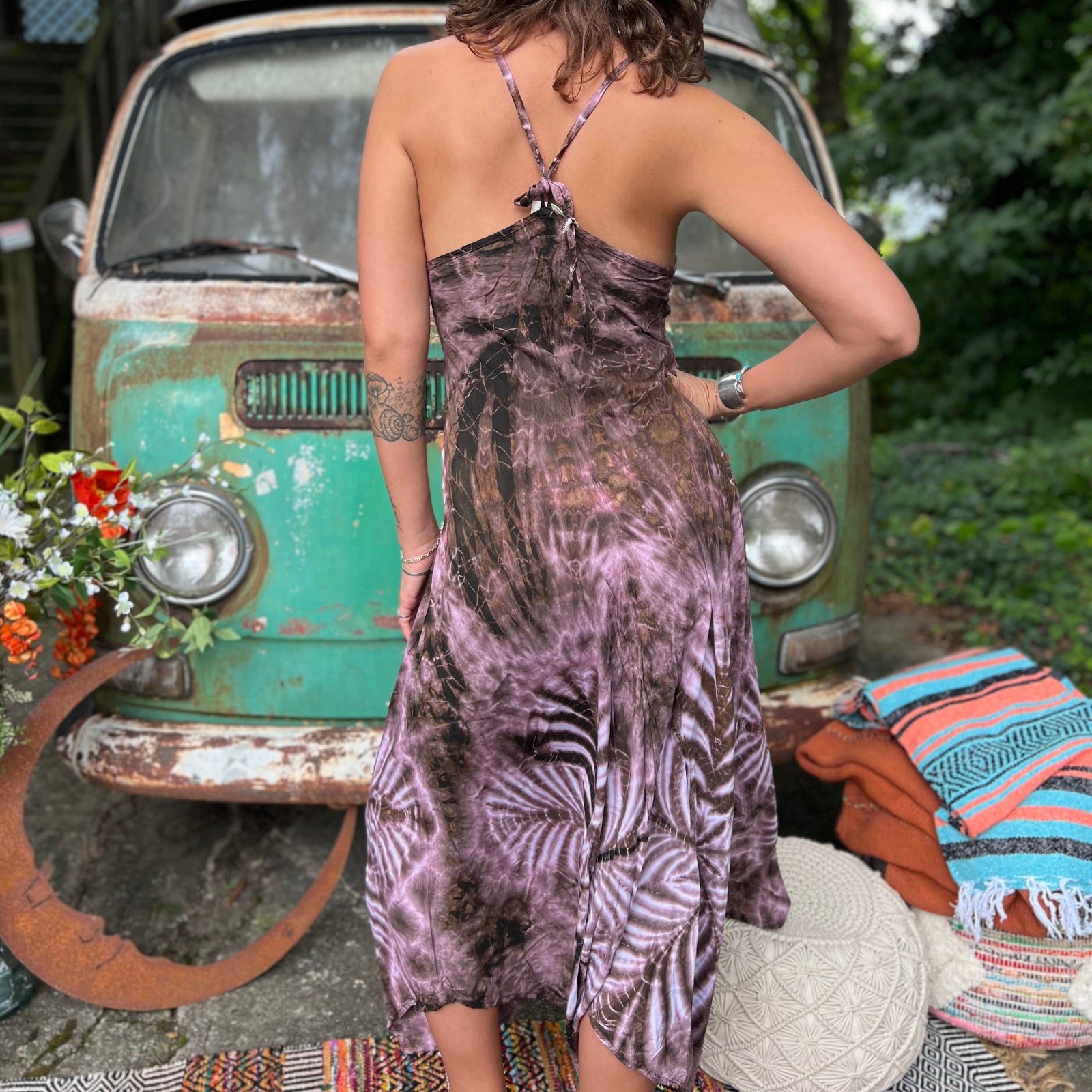 A woman wearing the moondance mauve gold Hippie Boho Maxi Flowy Tie Dye Dress in front of a vintage Volkswagen Bus.