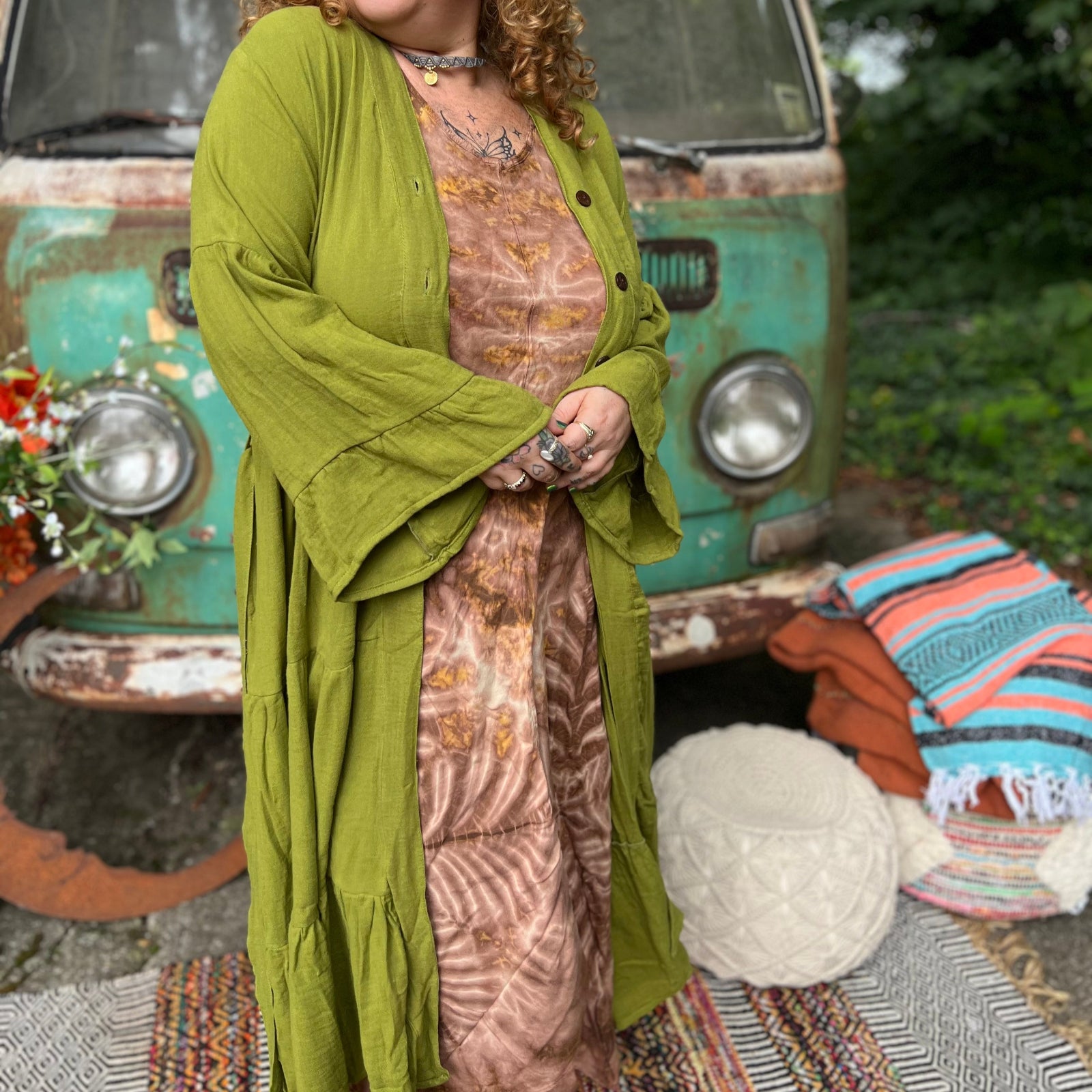 A woman wearing the golden Cyprus green Organic Tiered Maxi Kimono Wrap Dress in front of a vintage Volkswagen bus.