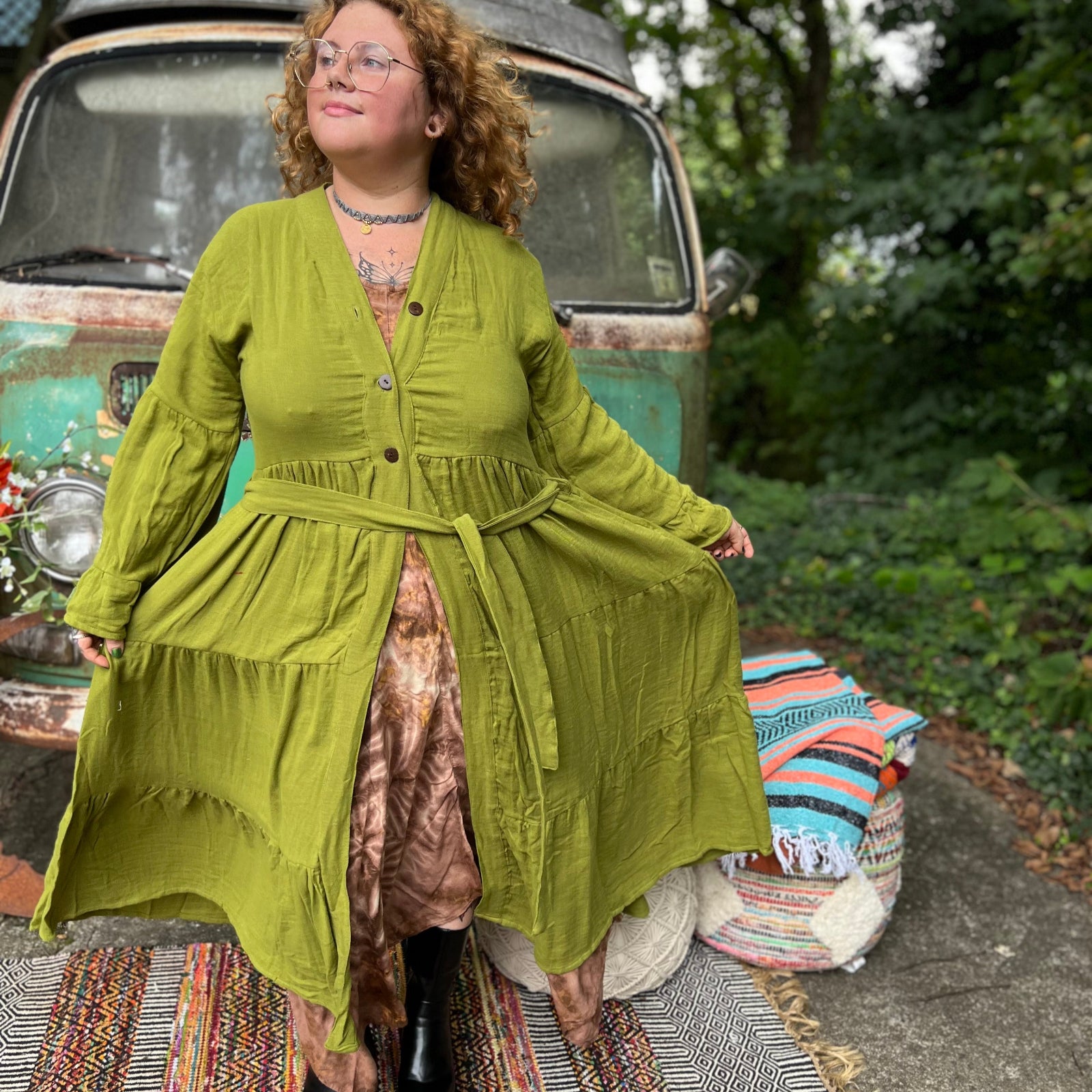 A woman wearing the golden Cyprus green Organic Tiered Maxi Kimono Wrap Dress in front of a vintage Volkswagen bus.