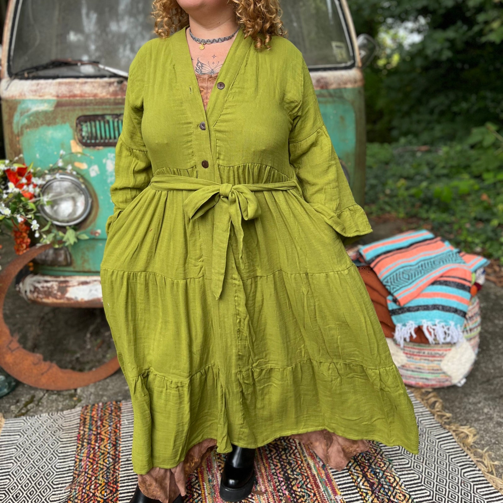 A woman wearing the golden Cyprus green Organic Tiered Maxi Kimono Wrap Dress in front of a vintage Volkswagen bus.