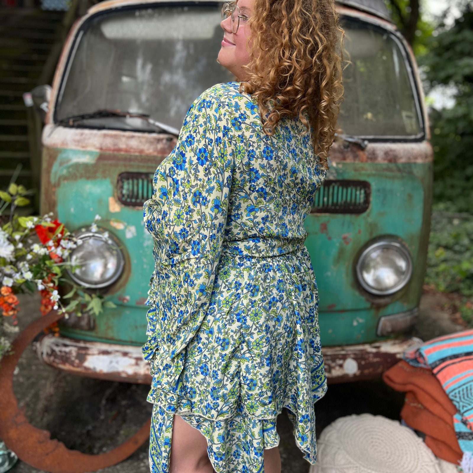 A woman wearing the green Hippie Bohemian Fairy Dress with Elastic Fairy Skirt in front of a vintage Volkswagen bus.